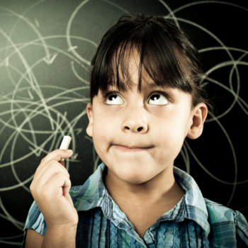 a young female student standing in front of a chalkboard with a piece of chalk in her hand. She looks like she's try to think of something or remember something