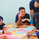 group of students talking with post its