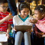 Three students sharing ideas in class