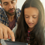 A dad helping his daughter with a PBL project at home